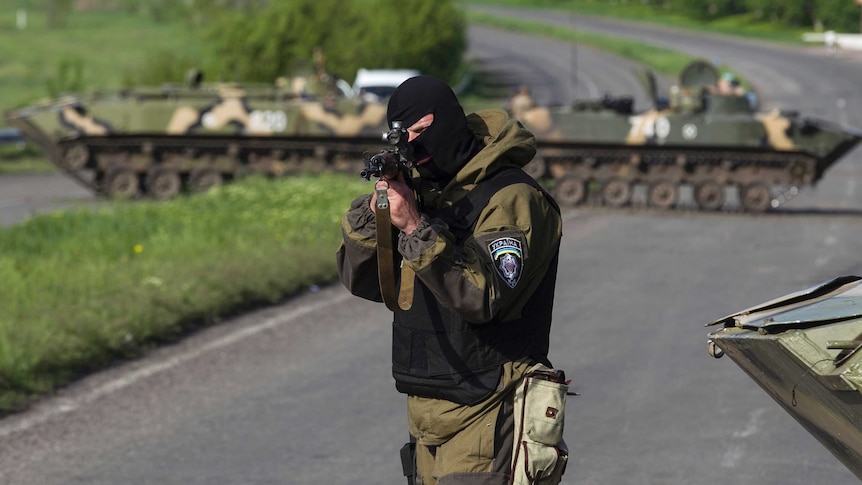 A Ukrainian soldier points his weapon at an approaching car at a checkpoint near the town of Slaviansk in eastern Ukraine.