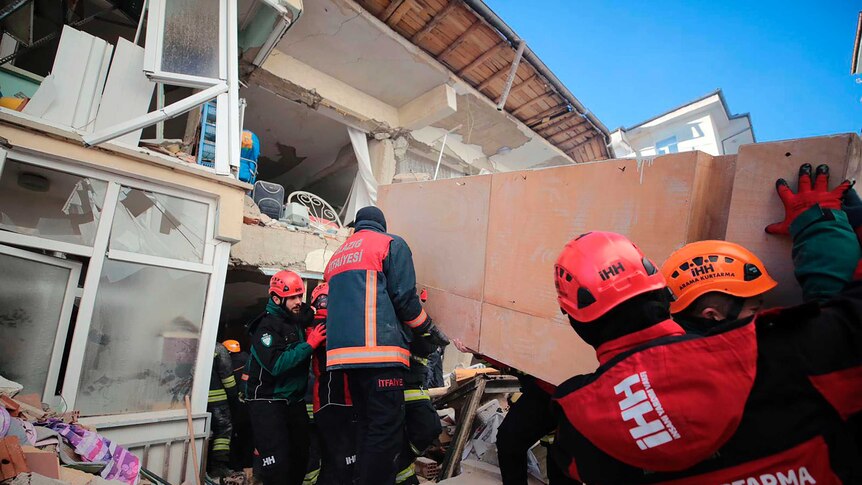 Rescuers work on searching for people buried under the rubble on a collapsed building in Elazig.