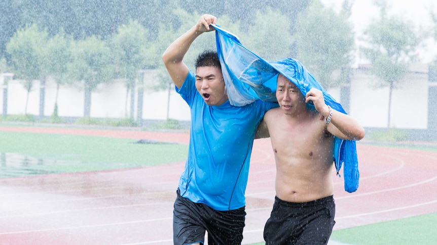 Two men running in the rain.
