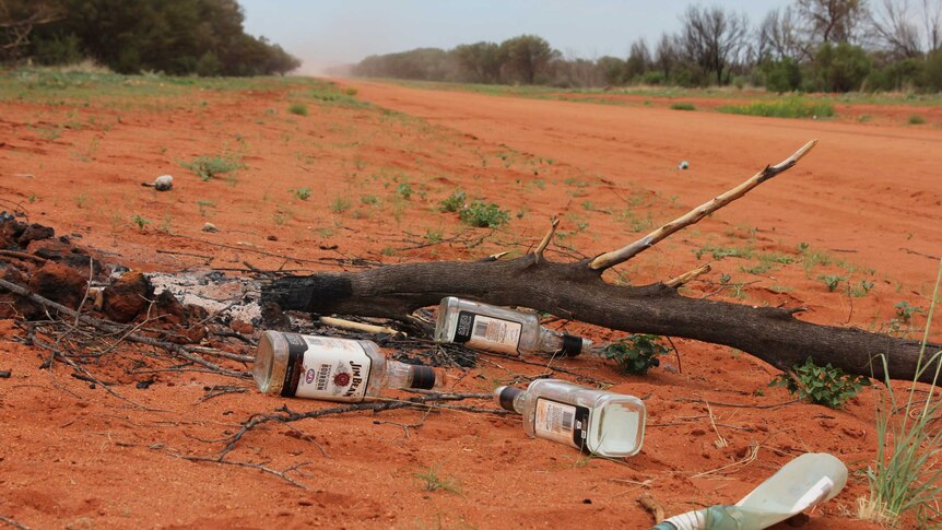 Empty bottles of alcohol discarded on the road into Papunya