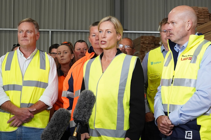Group of people wearing yellow and orange Hi-Vis smiling to the camera.