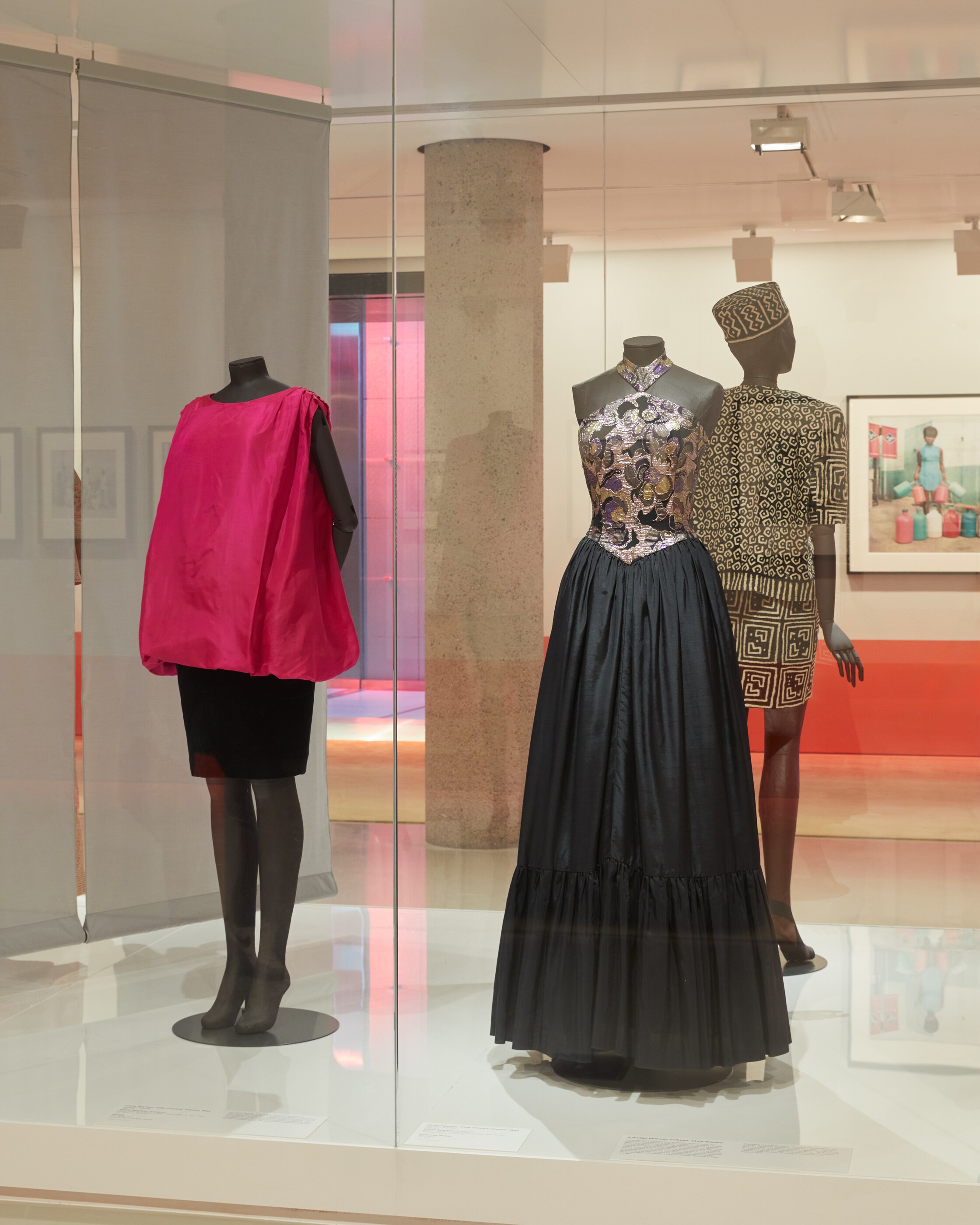 A ball gown with a gold, shimmery halter-neck and a black puffy skirt. And a pink shirt draped over a black pencil skirt. 