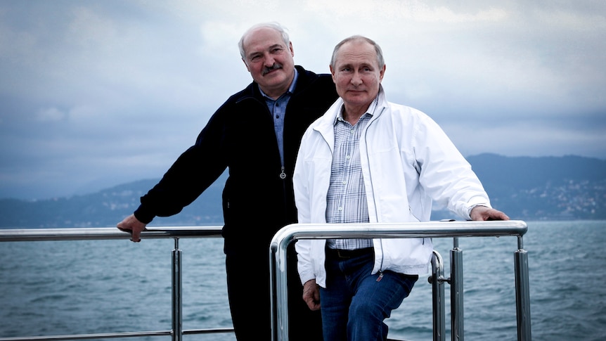 Putin and Lukashenko smile and pose together on a ship