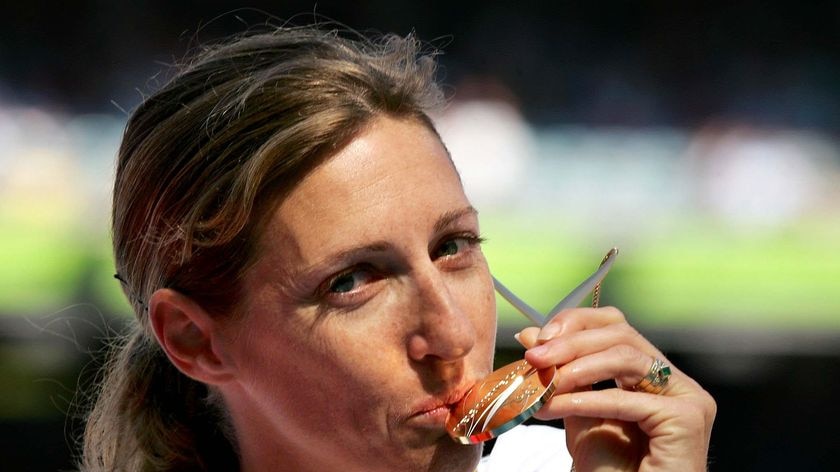 Kerryn McCann kisses her gold medal at the Melbourne 2006 Commonwealth Games
