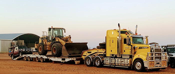 A truck carries a bulldozer bound for grazing properties in Winton.