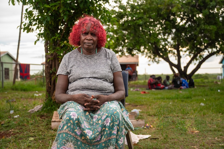 A woman sits on a stool in Wadeye. 