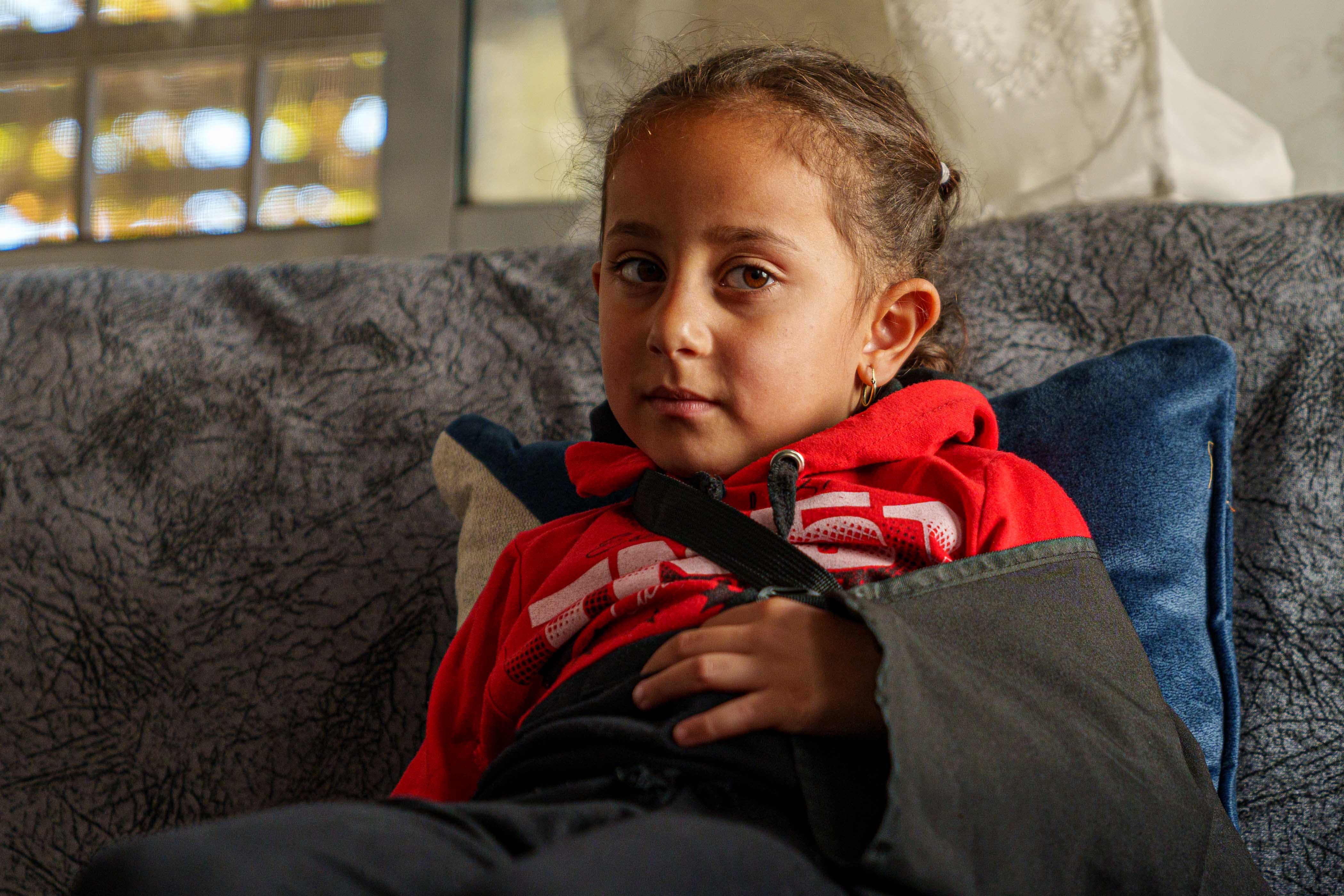 A little girl with a black sling on her arm