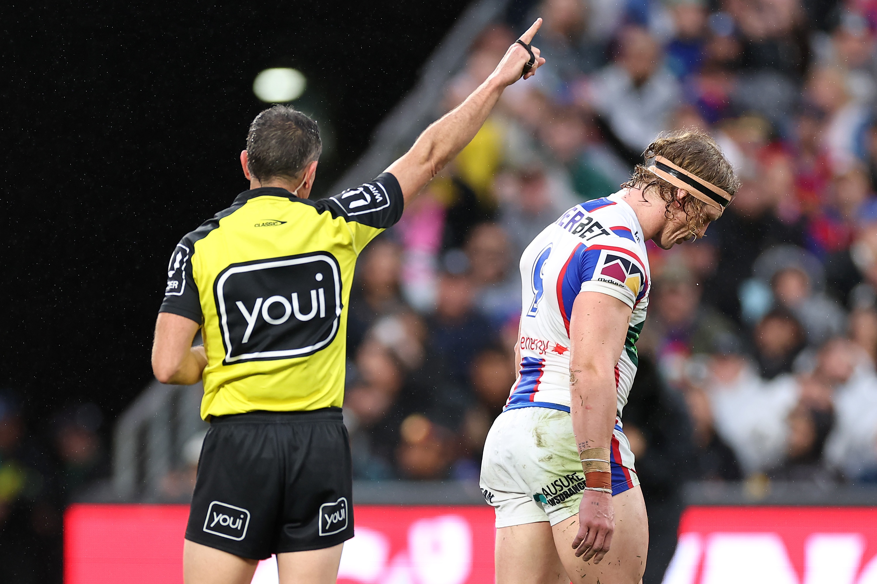 Phoenix Crossland walks off the field as referee Gerard Sutton points to send him off.