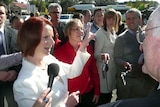 ALP candidate, Annabelle Digance, listens as Julia Gillard speaks to a member of the public