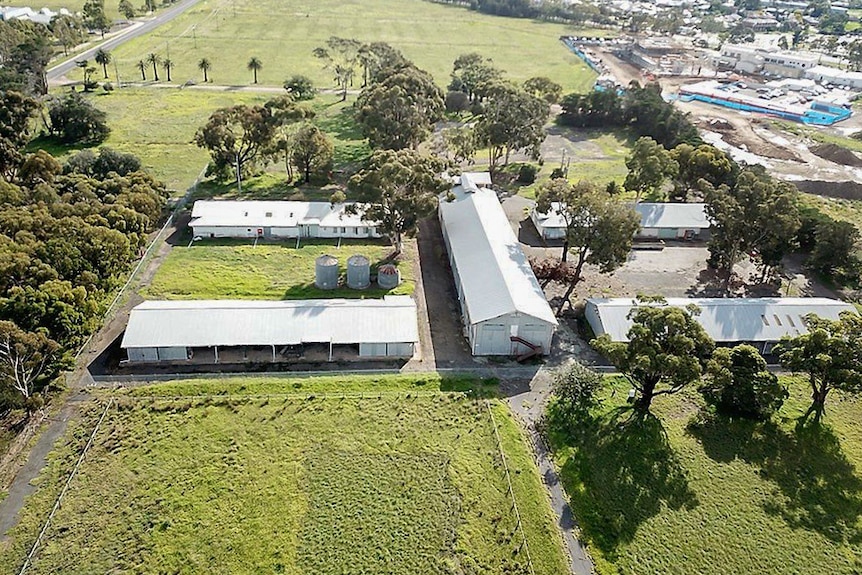 An aerial photo of five long sheds positioned in the shape of the letter H.