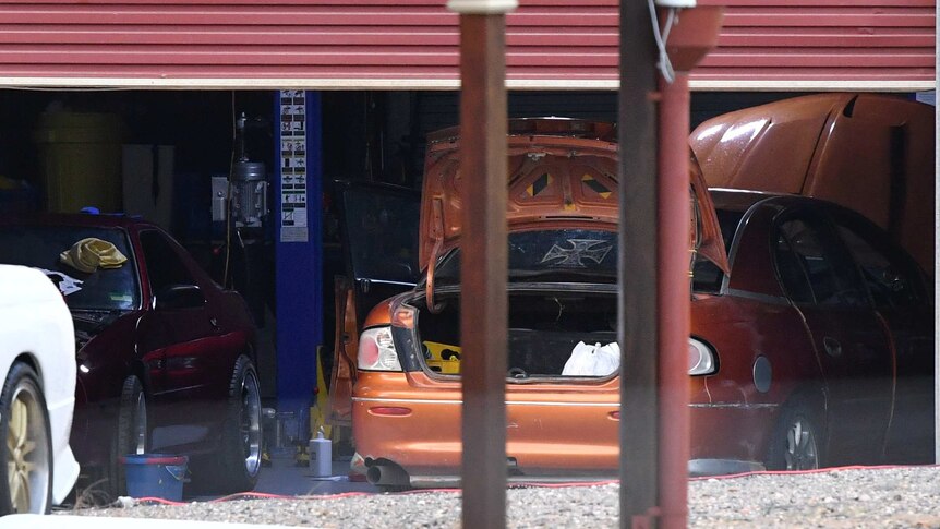A close up shot of a shed containing cars is seen behind a house in the suburb of Buccan.