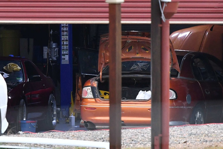 A close up shot of a shed containing cars is seen behind a house in the suburb of Buccan.