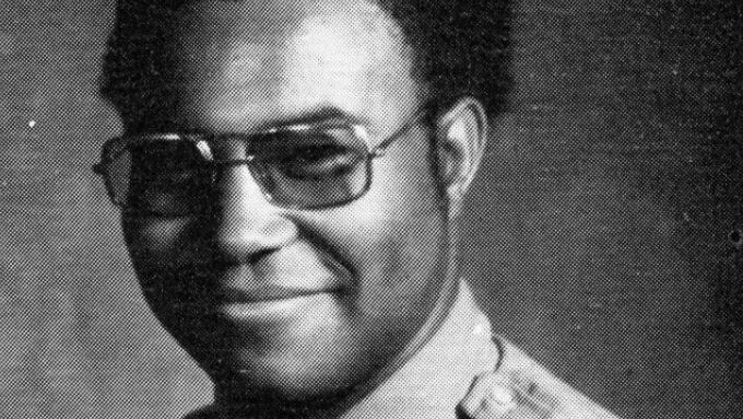 A black-anc-white photo of an African American police officer posing for an official photo.