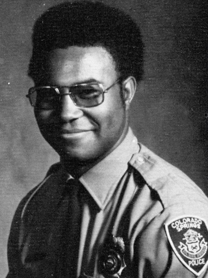 A black-anc-white photo of an African American police officer posing for an official photo.