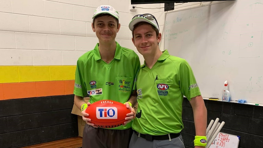 Jonty Beard hold a football in the change rooms before his first umpiring match.