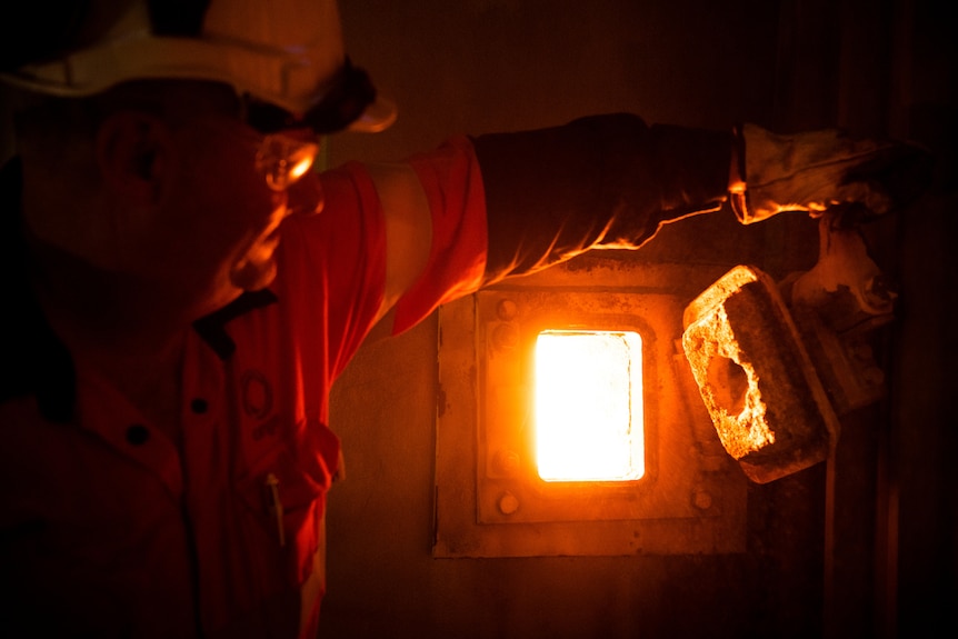 A man looks into a boiler 