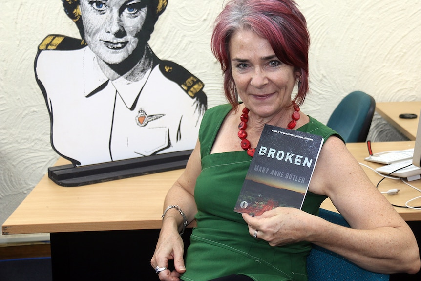 Mary Anne Butler holding a copy of her play Broken.