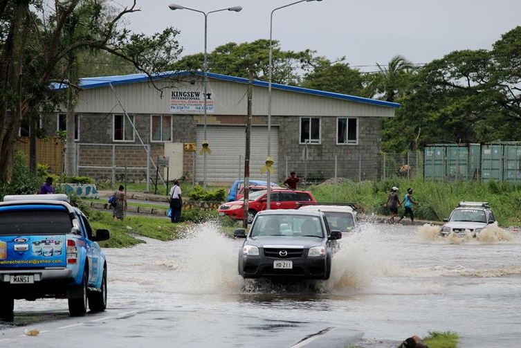 Cars drive through floodwater in Nadi.jpg