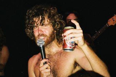 Rock singer Al Dear on stage with a can of beer.