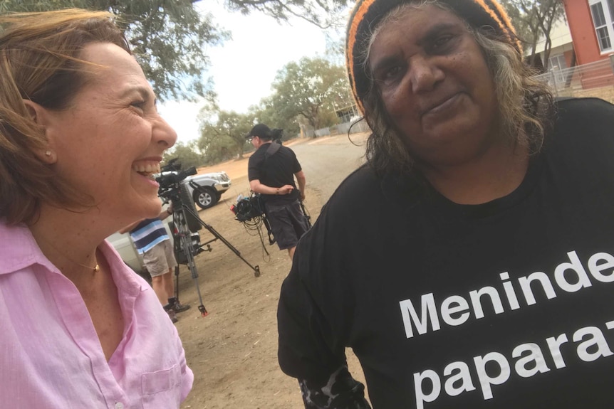 Millar laughing as Sloane looks at camera with crew in the background.