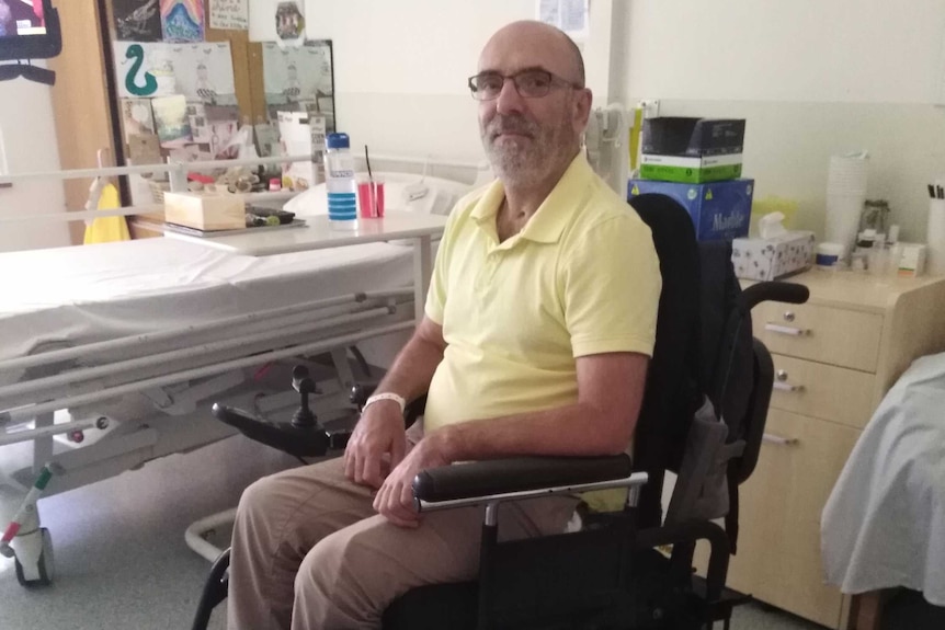 Trent Ferrier in a wheelchair in a hospital room.