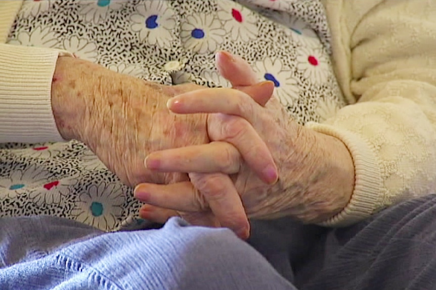 hands of an elderly woman resting on her lap