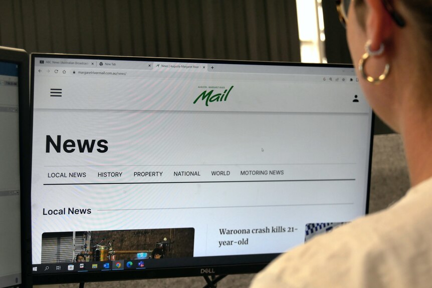  A woman reads the Augusta-Margaret River Mail on a computer.