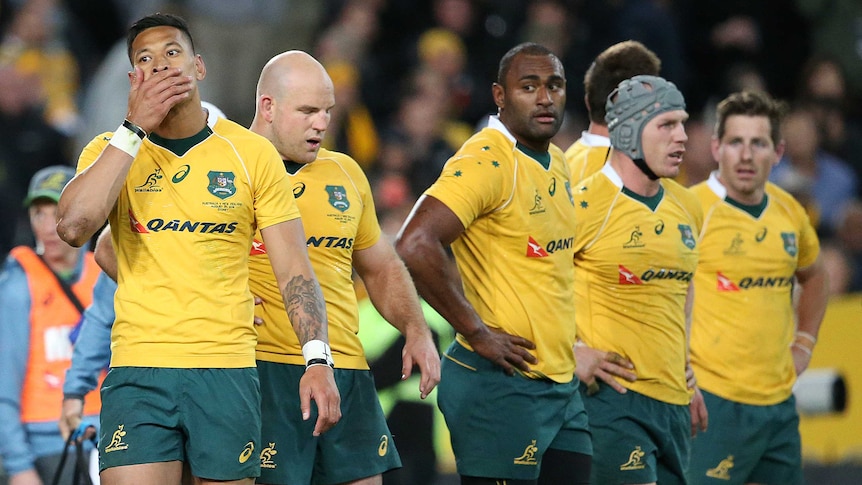 A group of dejected rugby players react after an international.