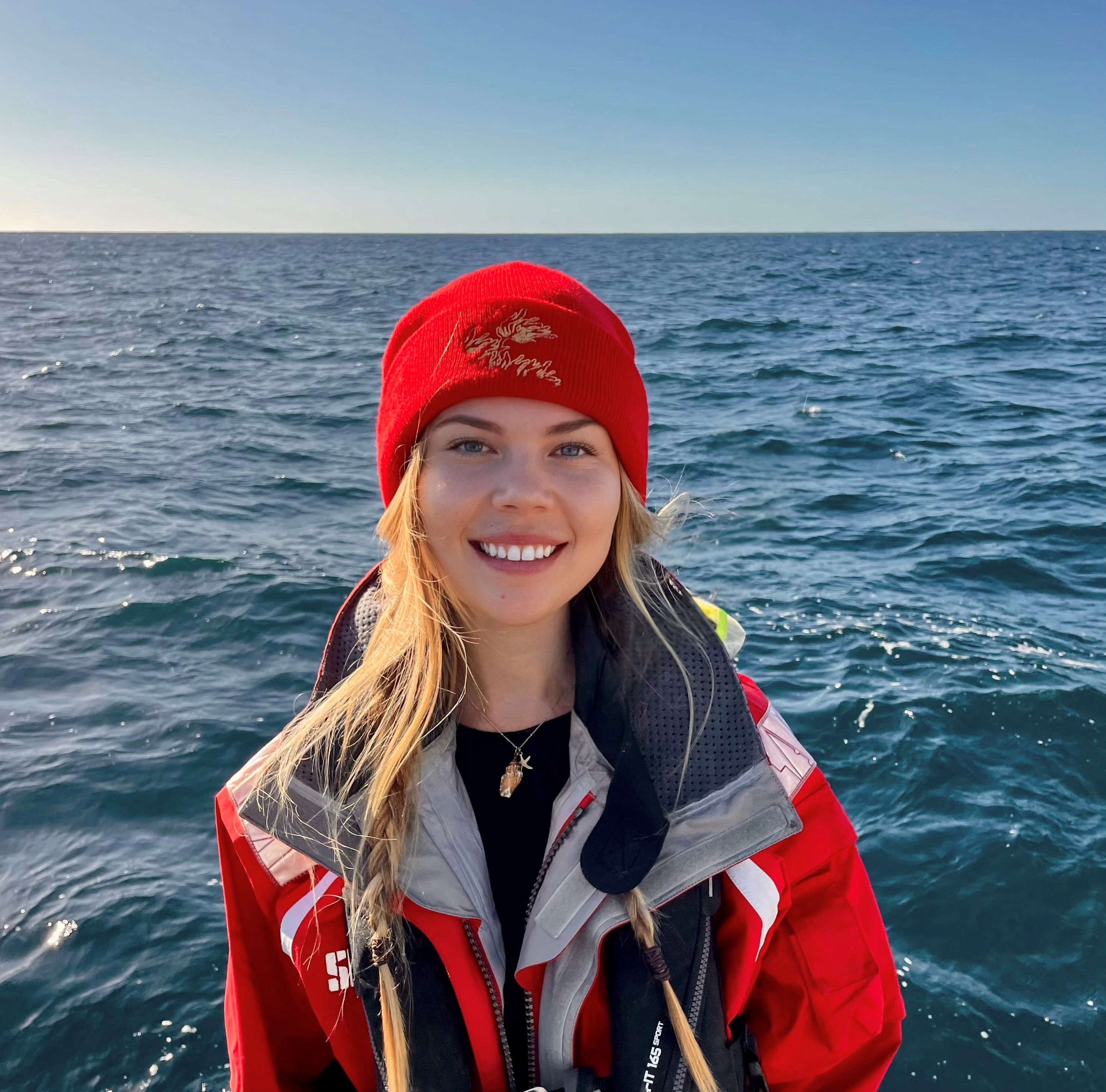 Imagen de Shinae con pelo largo, sombrero y chubasquero en un barco en el mar.