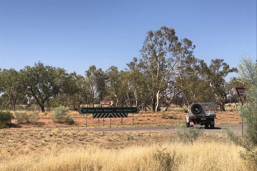 A police car near a sign to Emily Gap