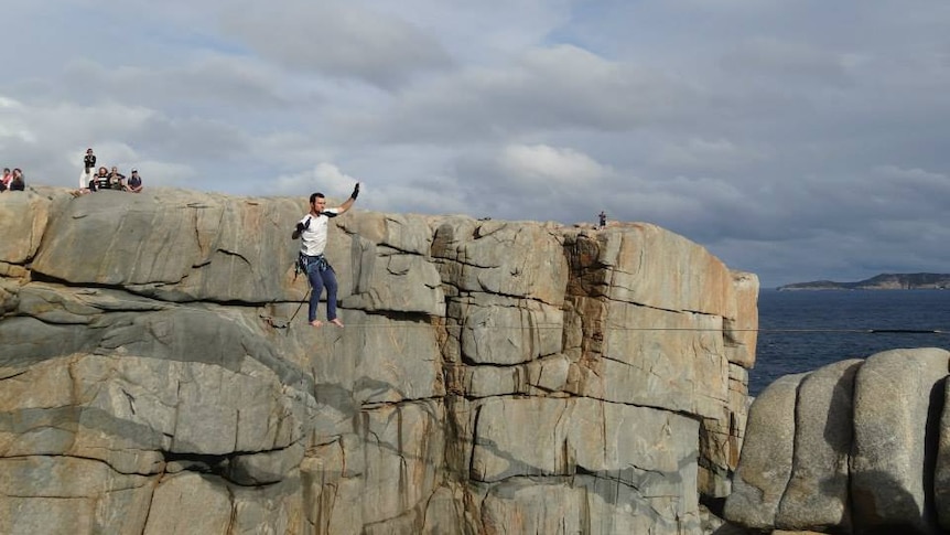 A man tightropes across the tourist attraction of The Gap.