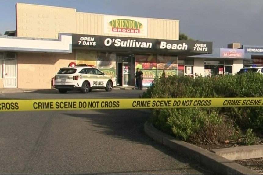 A supermarket with a police car and crime scene tape across it