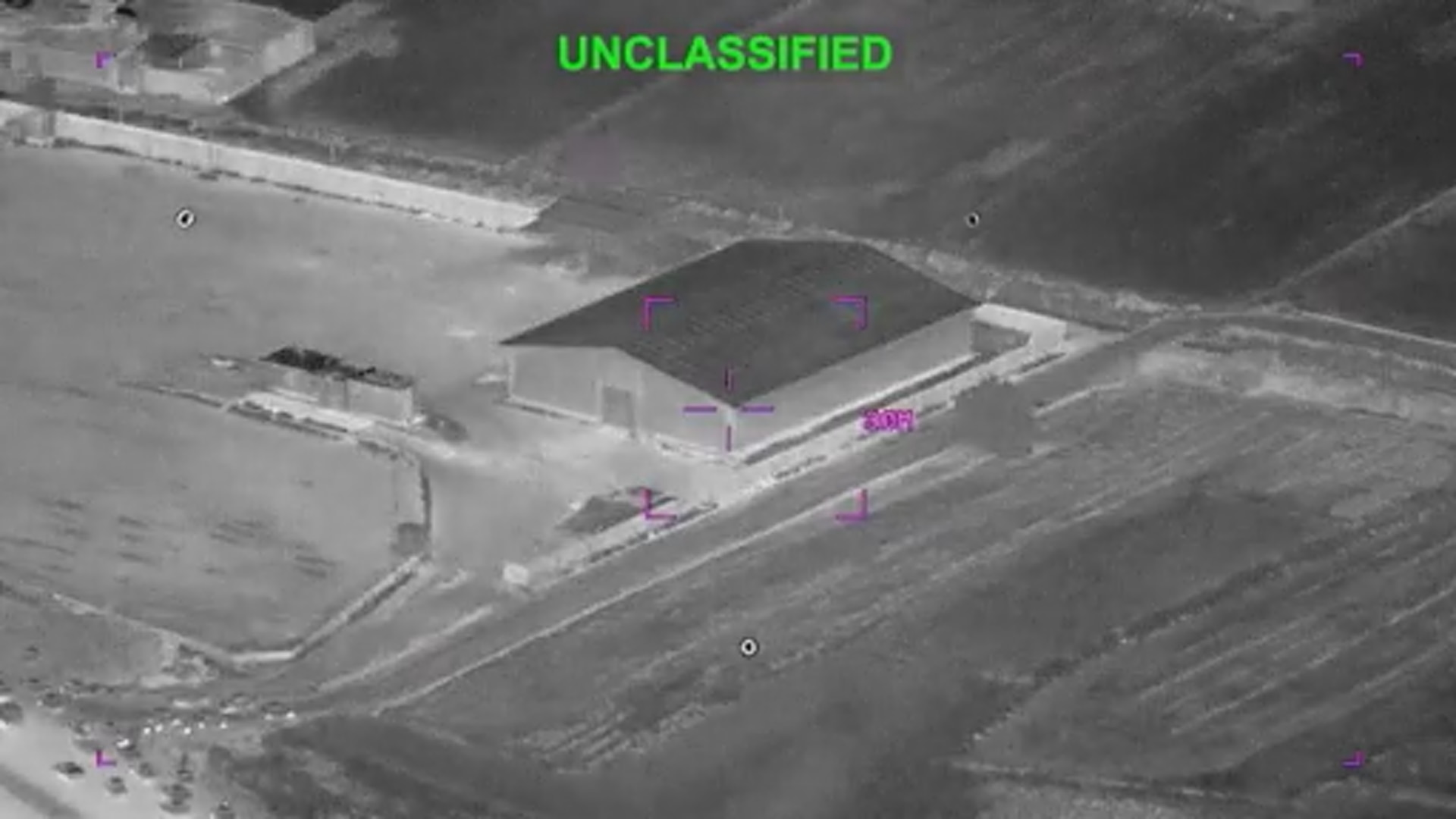 A still frame from a video of a building in crosshairs