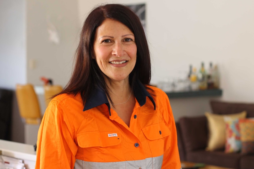 Corinne Brown wearing a fluoro shirt and smiling at camera