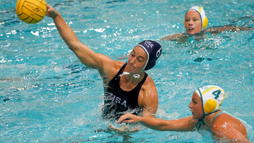 A woman playing water polo takes a shot at goal by leaping high out of the water. 