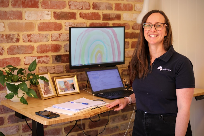 A woman at home at a stand-up desk with a laptop on it. 