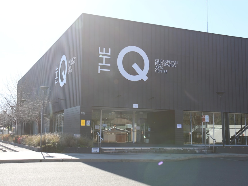 A big square building bears the sign "The Q".