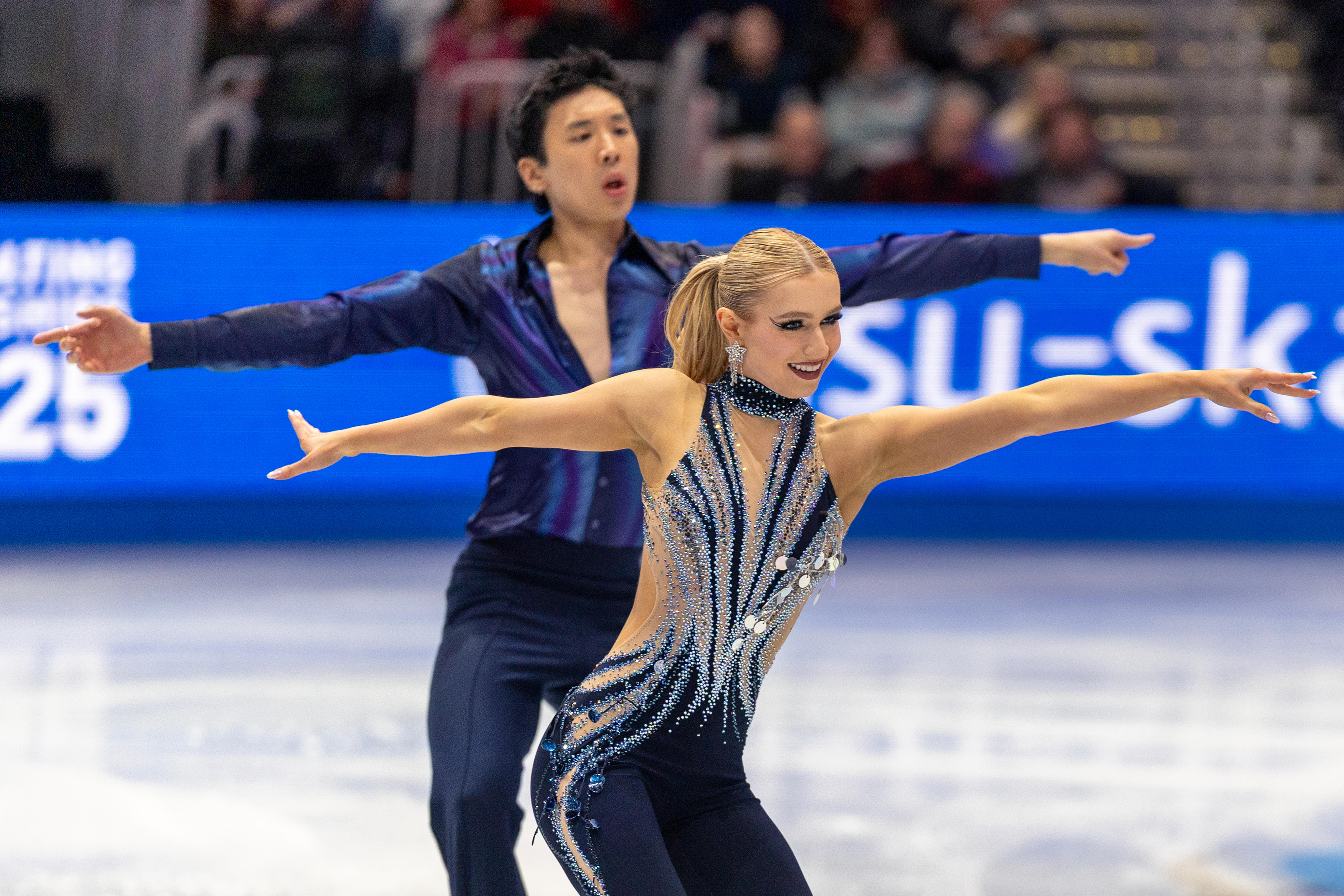 Holly Harris e Jason Chan patinam com os braços estendidos
