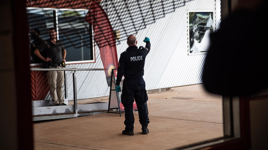 Police looking at a break in through a dark window