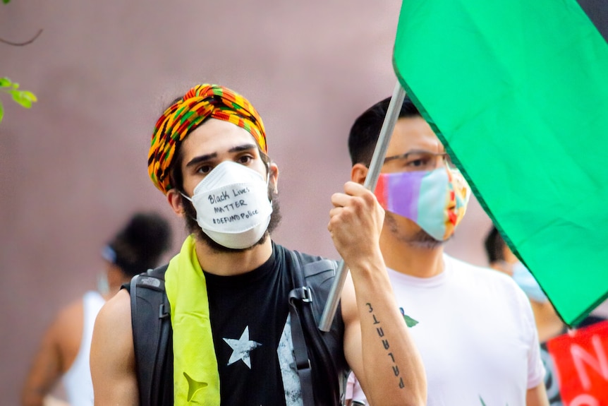 Two young men attend a protest in face masks
