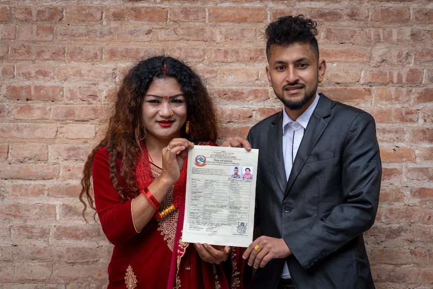 First same-sex married couple in Nepal hold up their marriage certificate.