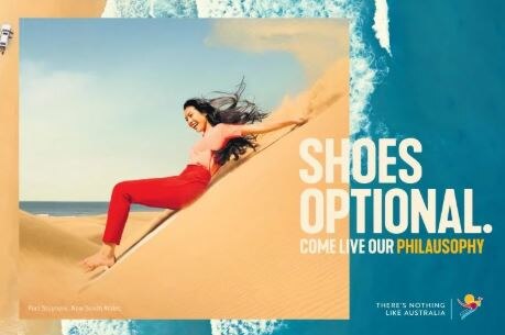 A woman slides down a sandhill in the new Tourism Australia ad campaign.
