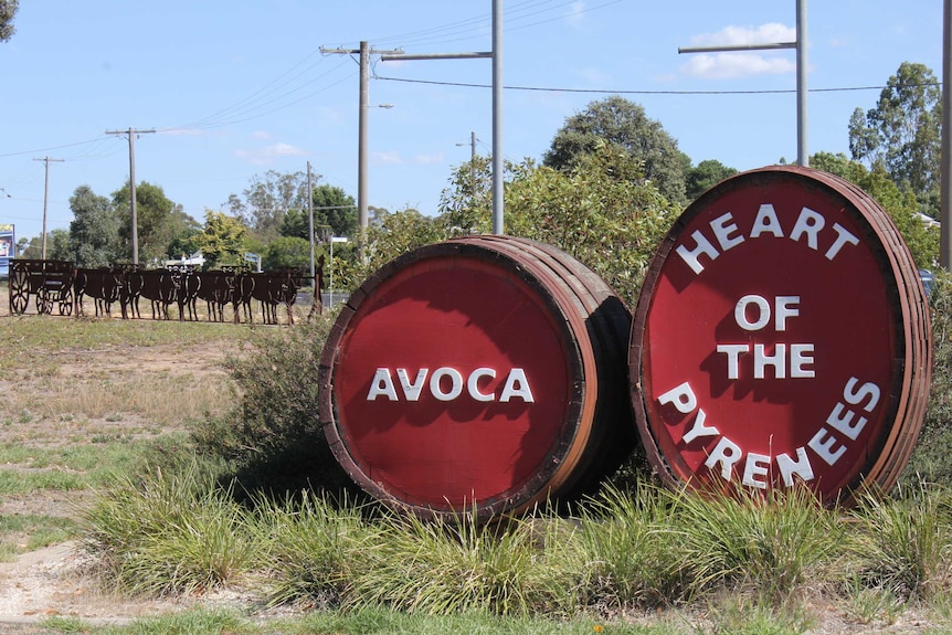 Red Wine Barrels sculptures with an Avoca sign sit in the main street of a rural town.