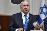 Israeli Prime Minister Benjamin Netanyahu looks at the camera sternly.