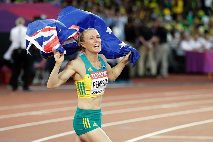 Sally Pearson celebrates while carrying the Australian flag.