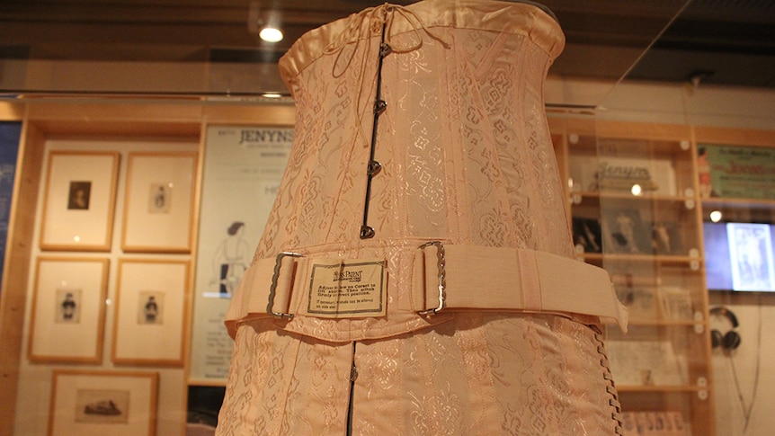 A pink corset on a mannequin torso in the State Library of Queensland.