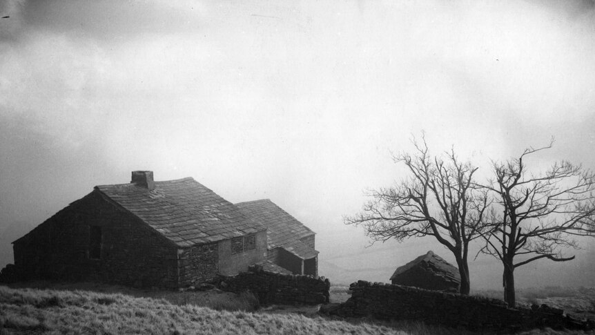 A black and white photo of an old country station in the moors