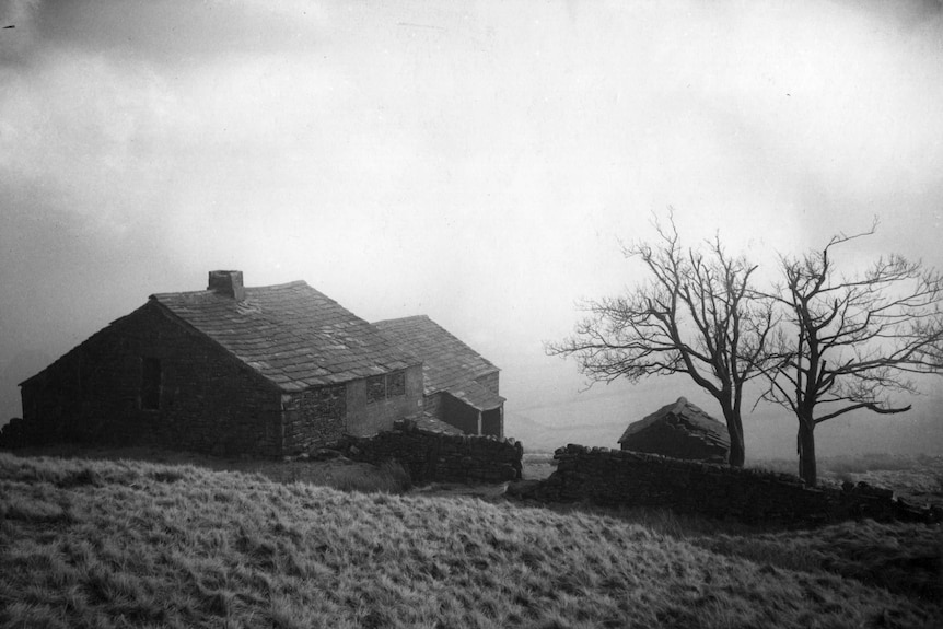 A black and white photo of an old country station in the moors