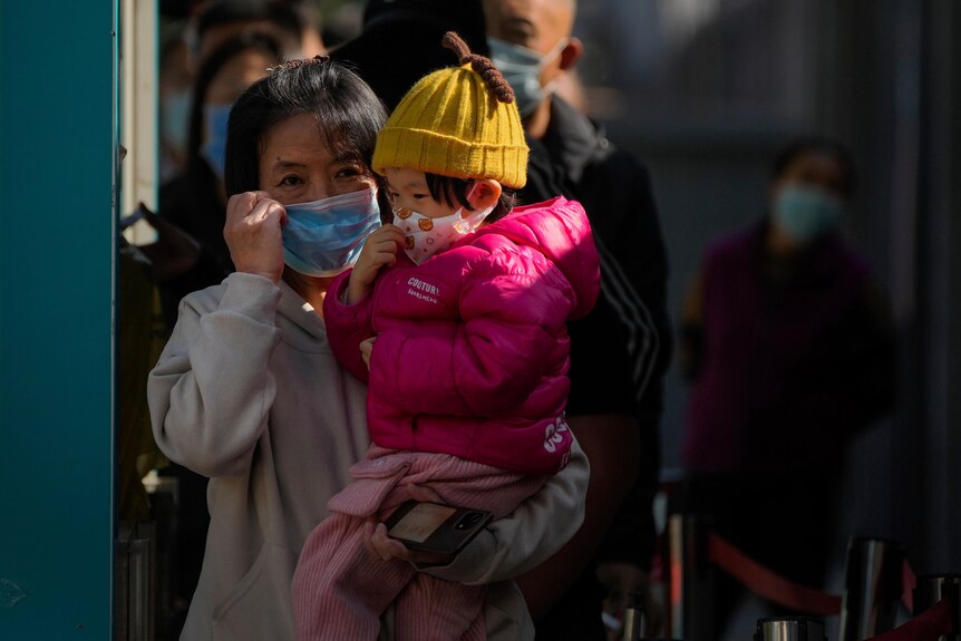 A woman and child in masks after throat swab