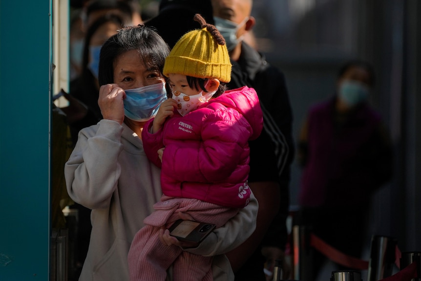 A woman and child in masks after throat swab